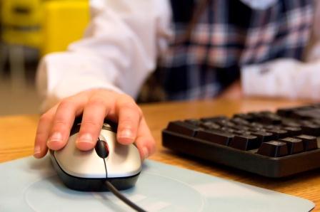 Child’s hand on a computer mouse.